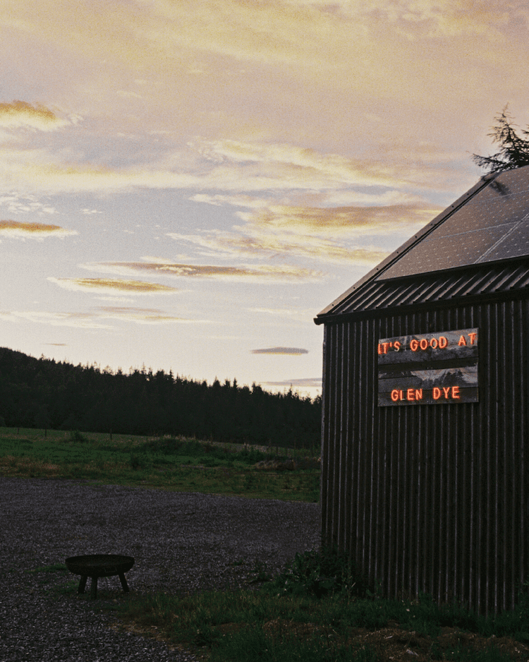 The community cinema at Glen Dye with its neon sign lit up in orange, reading "It's good at Glen Dye"