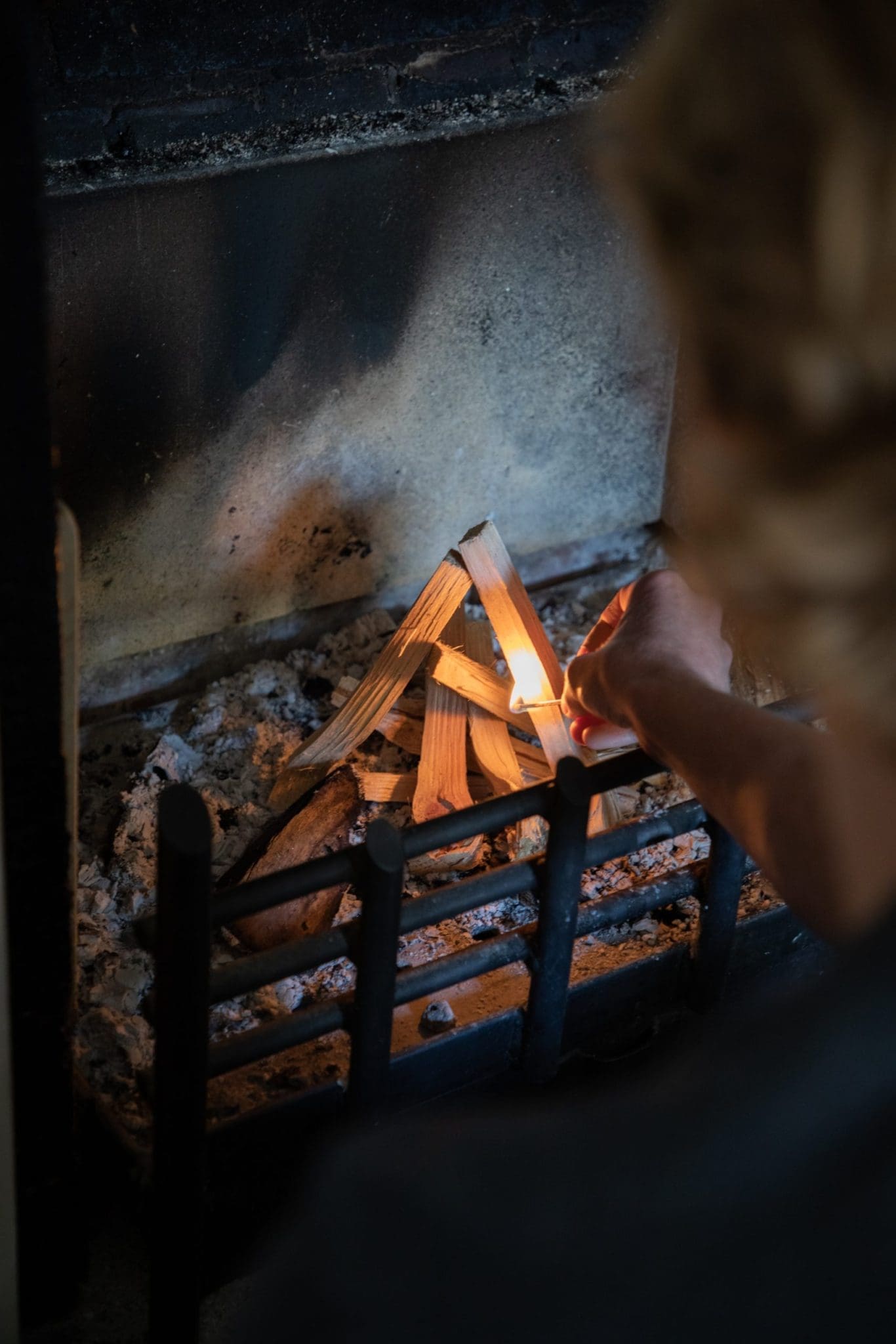 Thin pieces of wood stacked together in a fire place being with a match.