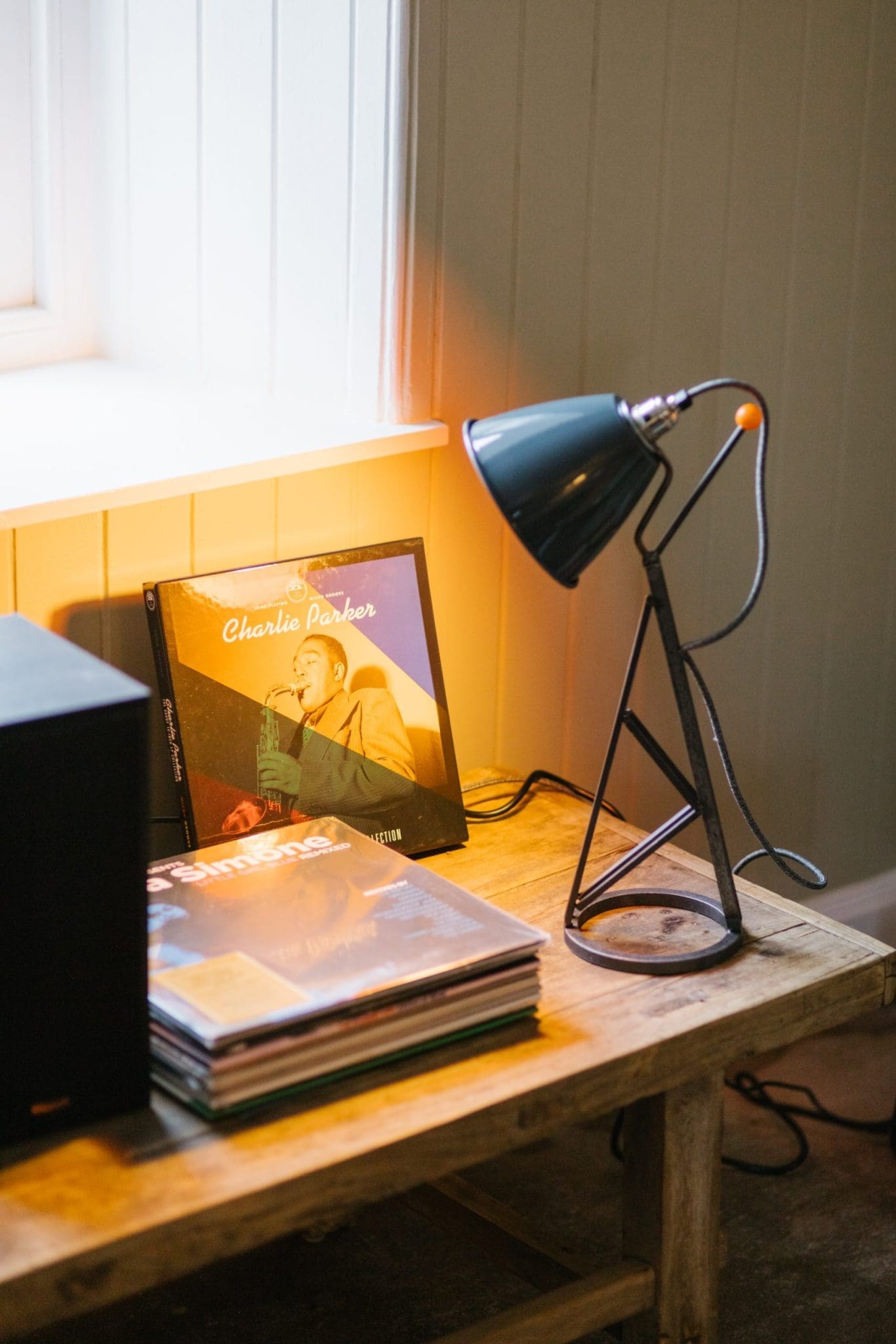 A photo from the Cuttieshillock Cottage collection, with a focus on a lit table lamp shining onto a Charlie Parker CD.