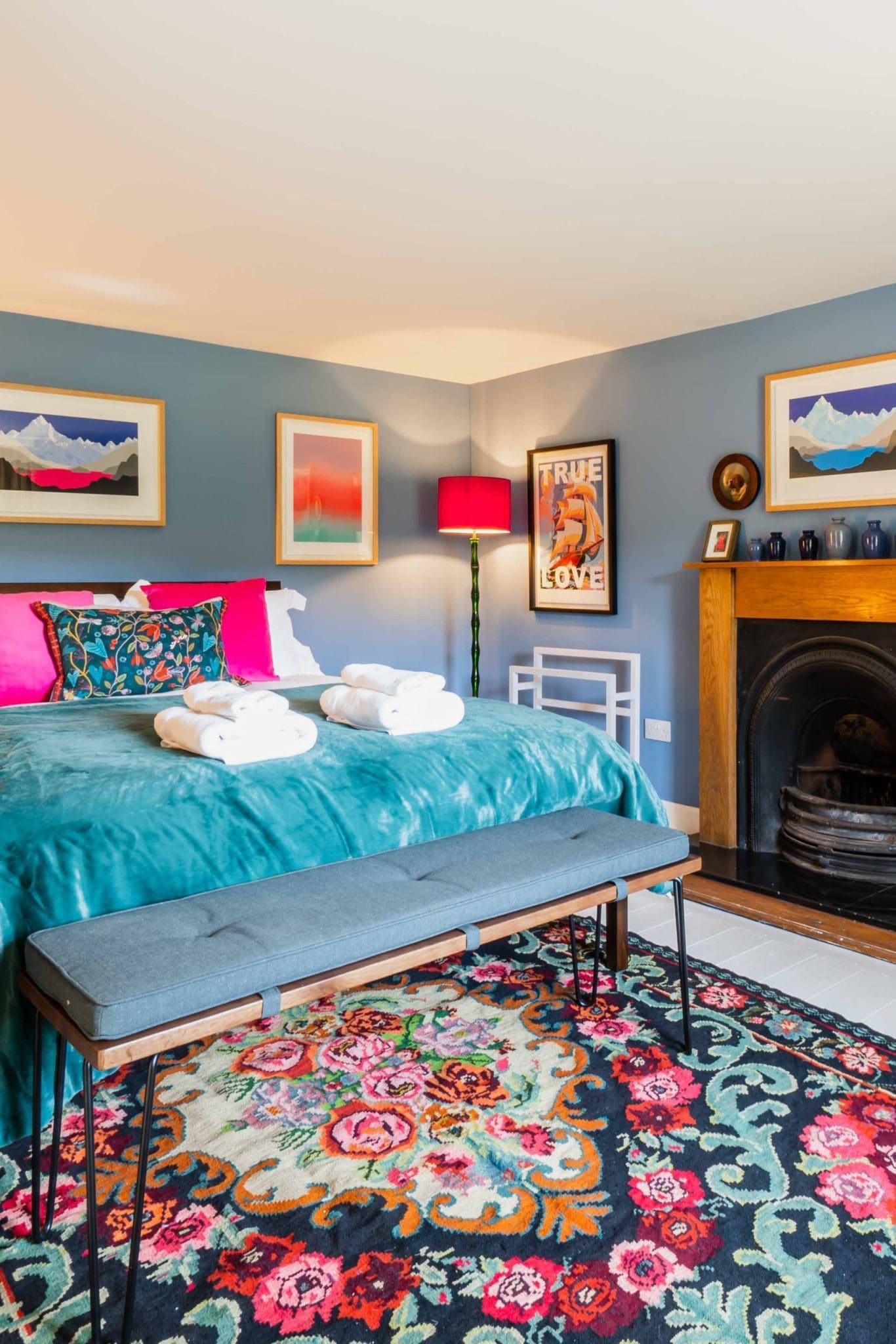 Luxury King room at the Coach House with a king bed floral rug period fireplace and modern art at Glen Dye Cabins and Cottages