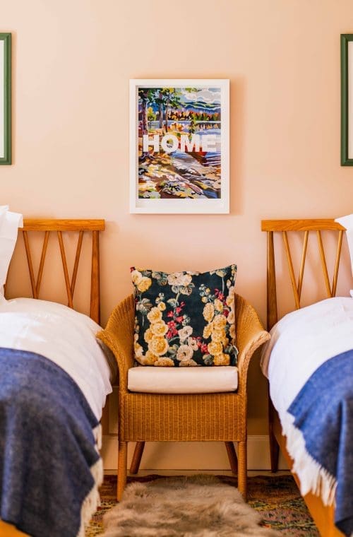 Luxury bedroom with twin beds rattan chair and framed print