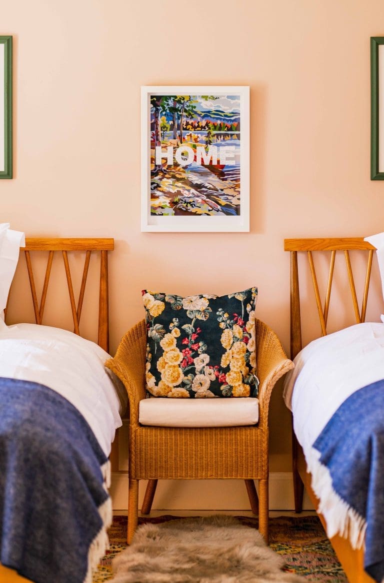 Luxury bedroom with twin beds rattan chair and framed print