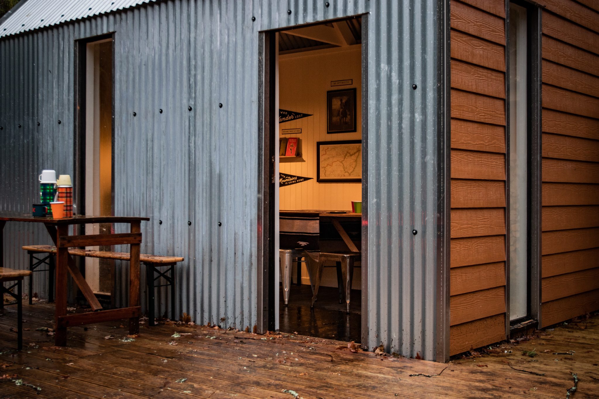 Looking into the lit North lodge cabin with a focus on the posters and pictures on the walls.