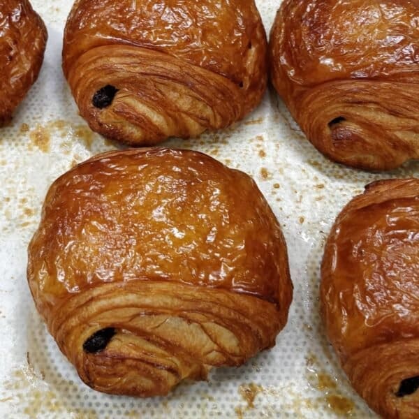 Freshly baked Single Origin Pain Au Chocolat sitting on top of baking paper