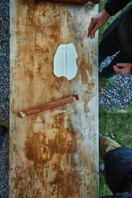 Top down view of dough being rolled out in preparation of making flat bread