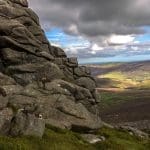 A photo taken of the view from Mount Clachnaben overlooking a vast amount of hilly green land.